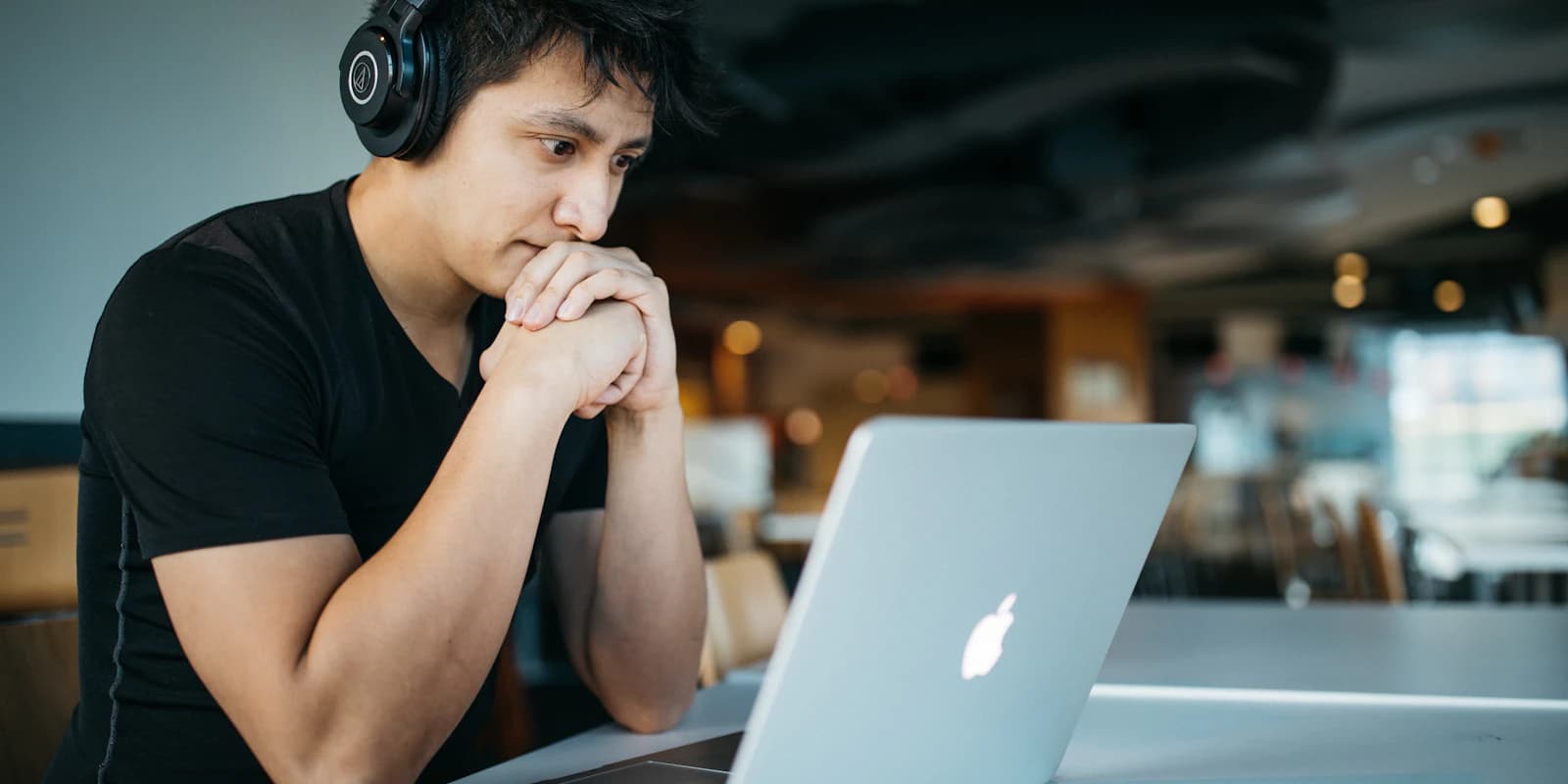 Un candidato con auriculares avanzando con calma por una evaluación en línea en un portátil