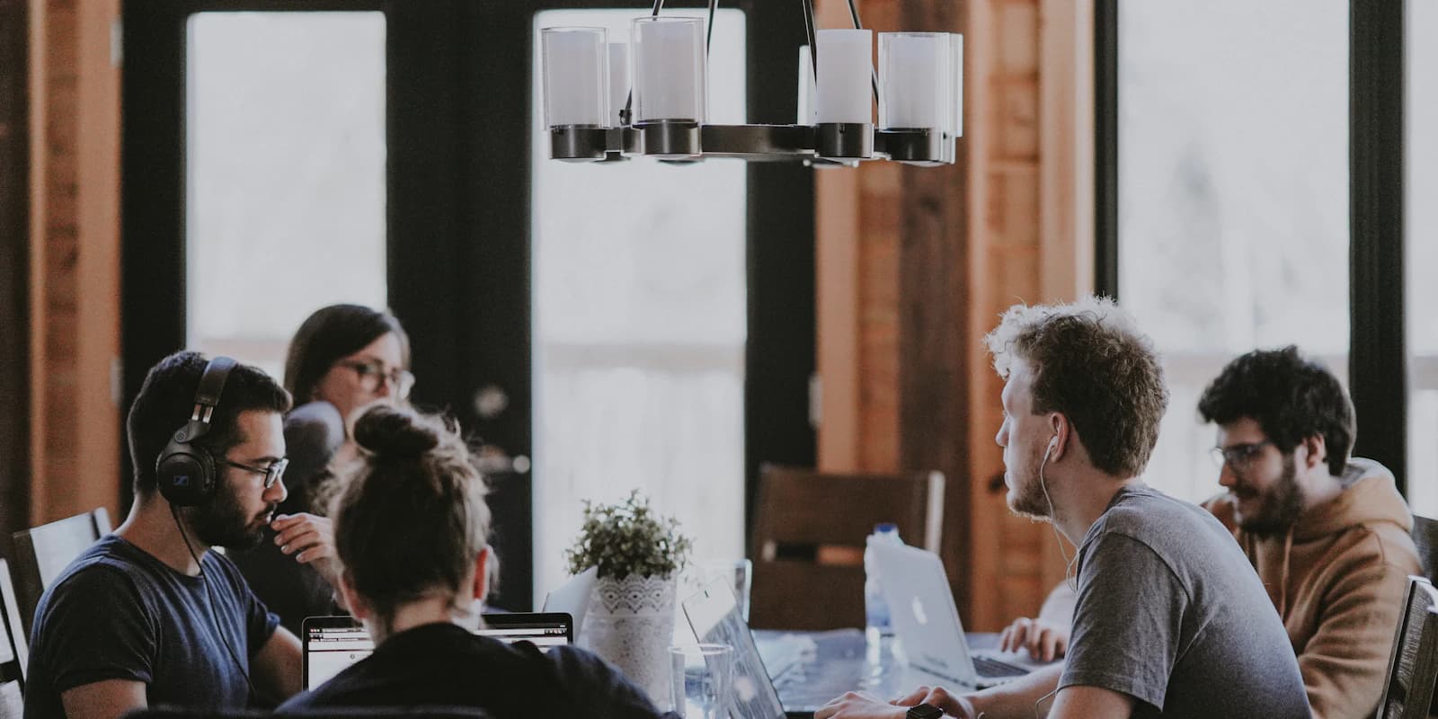 Un equipo multidisciplinar colaborando alrededor de una mesa, construyendo capacidad a través del trabajo real